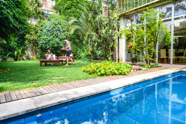 vue au-dessus de la piscine de jeunes couples appréciant le petit déjeuner à l'extérieur - garden decoration photos et images de collection
