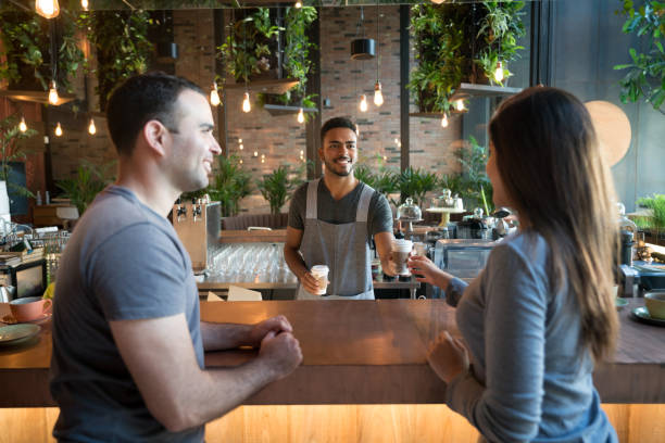 waiter serving coffee to a couple at a cafe - junk food stock pictures, royalty-free photos & images