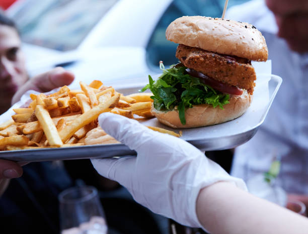 Waitress at The Haus restaurant serves burgers and fries with gloves during the Corona crisis. Photo: Annette Riedl/dpa-Zentralbild/ZB