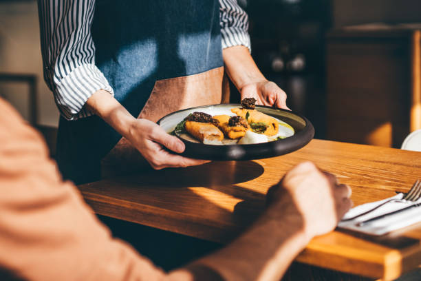 waitress serving food in a restaurant. - food stock pictures, royalty-free photos & images