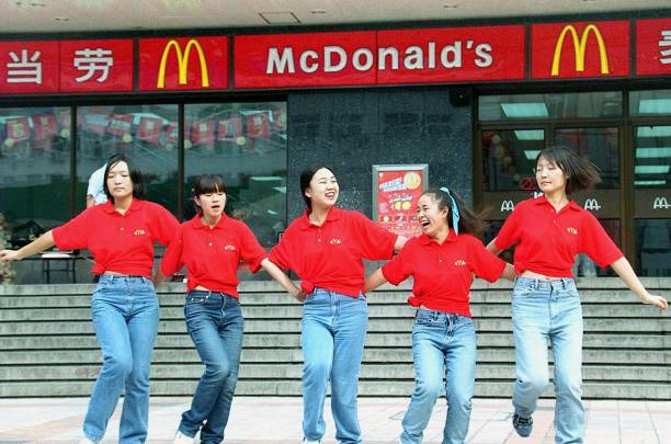 Waitresses from the US fastfood giant McDonald's dance outside an outlet in Beijing 03 October 2000 to attract more customers during festivities to...