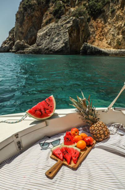 watermelon and fruit picnic on boat in greek lagoon - food stock pictures, royalty-free photos & images