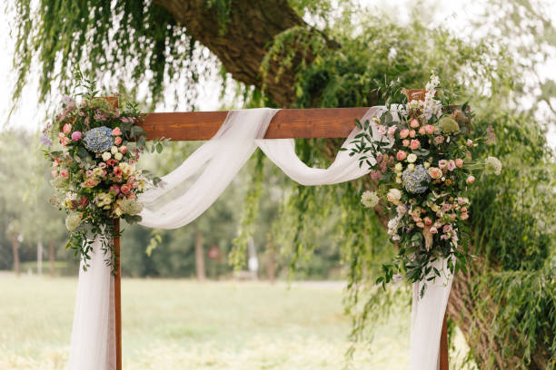 wedding arch decorated with flowers and greenery in rural area - garden decoration stock pictures, royalty-free photos & images