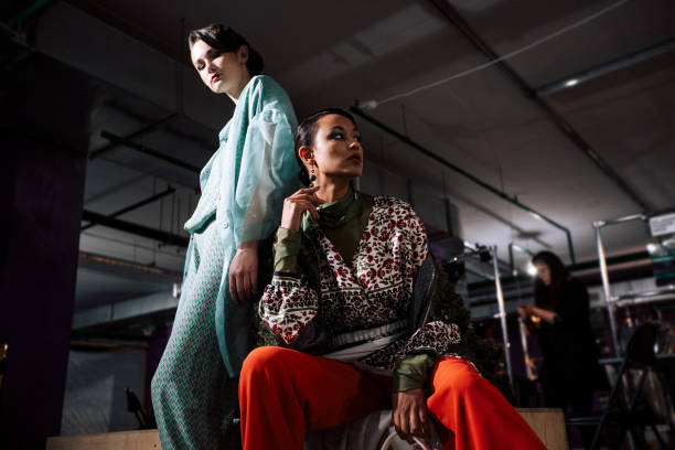 weibliches gruppenporträt von zwei models im innenbereich. hinter den kulissen der fashion week show, backstage-fotografie. die frauen hinter dem laufsteg tragen design-kleidung. lifestyle-foto mit beauty-menschen. - fashion 