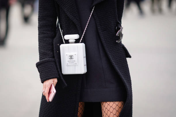 White Chanel bag shaped as a fragrance bottle is seen, outside Chanel, during Paris Fashion Week Womenswear Fall/Winter 2018/2019, on March 6, 2018...