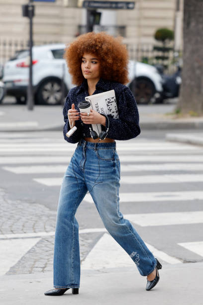 Whitney Peak wears blue tweed crop jacket, blue Chanel printed jeans, black Chanel heels, outside Chanel, during the Womenswear Fall/Winter 2025/2026...