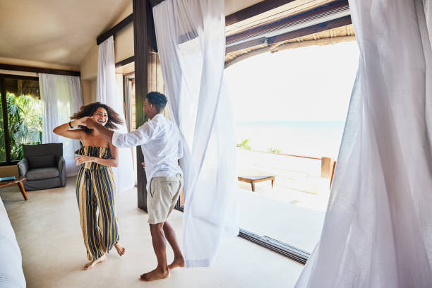 wide shot of couple dancing in luxury suite of tropical resort - travel stock pictures, royalty-free photos & images