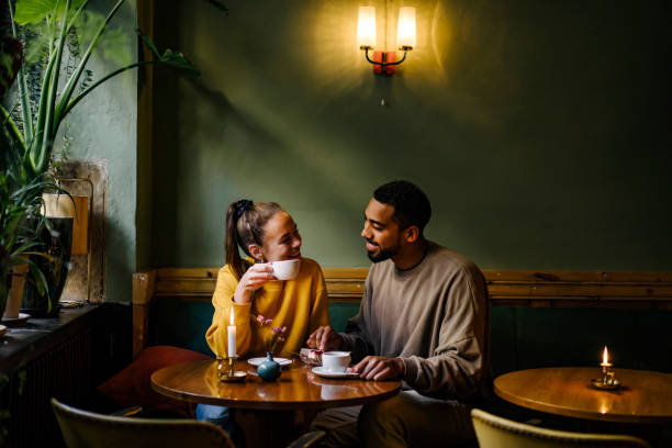 wide shot of couple having a conversation at a coffee shop - coffee stockfoto's en -beelden