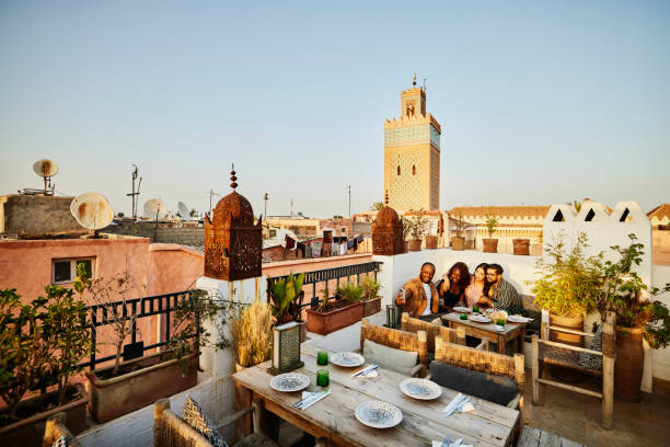 wide shot of couple taking selfie at rooftop restaurant in marrakech - travel stock-fotos und bilder