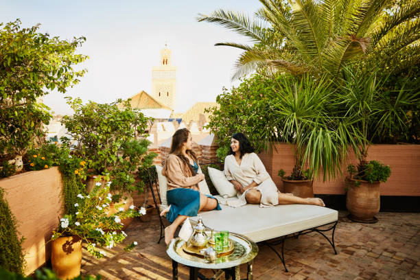 wide shot of friends relaxing in rooftop garden of luxury hotel - travel stock pictures, royalty-free photos & images