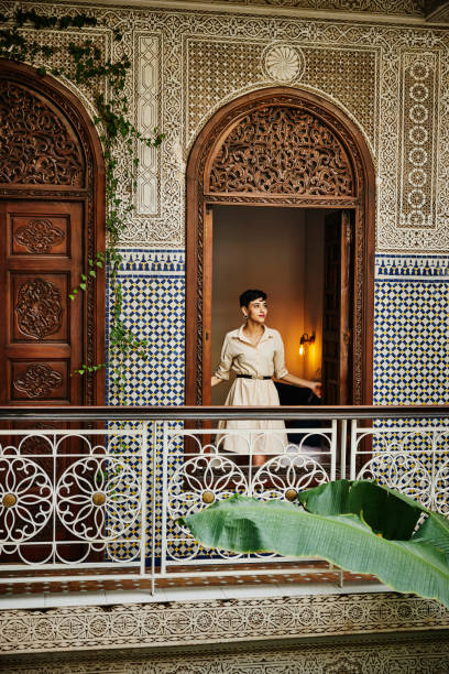 wide shot woman standing in bedroom window in raid while on vacation - travel stock pictures, royalty-free photos & images