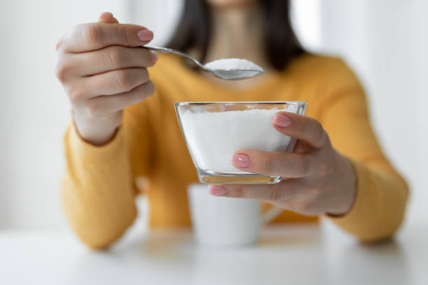 woman adding refined sugar to cup of coffee - food stock pictures, royalty-free photos & images