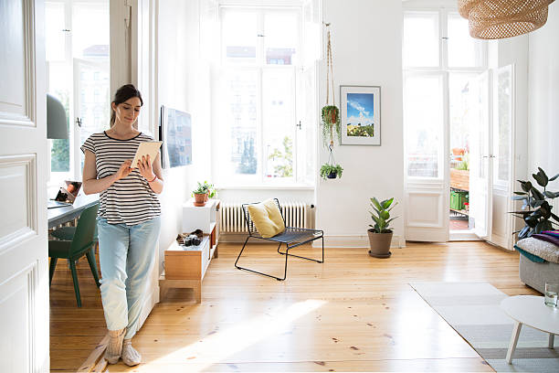 woman at home using tablet - home decoration photos et images de collection