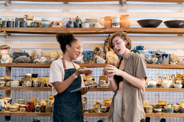 woman buying craft product from owner in store - home decoration stock pictures, royalty-free photos & images