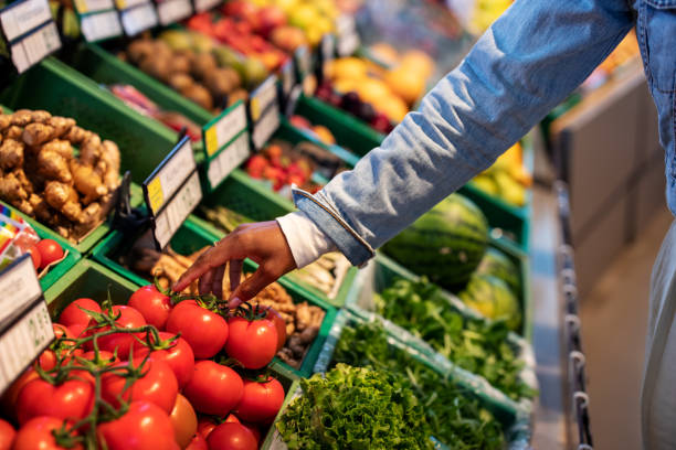 woman buying fresh vegetables at supermarket - food stockfoto's en -beelden