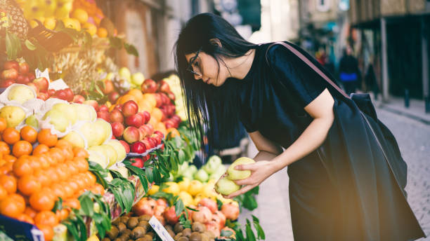 woman buying fruits on street market - food stock pictures, royalty-free photos & images
