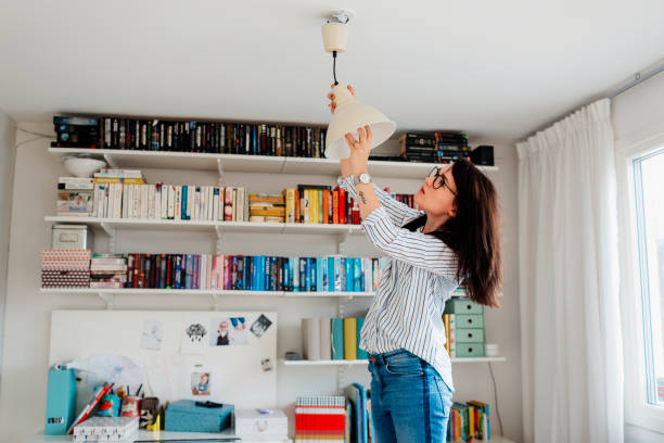 woman changing bulb in house - home decoration stock pictures, royalty-free photos & images