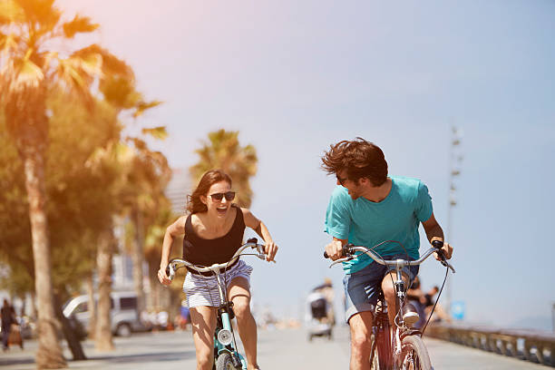 woman chasing man while riding bicycle - travel stock pictures, royalty-free photos & images