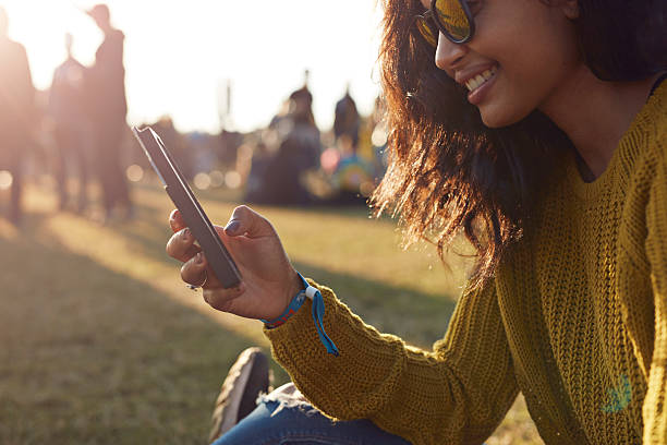 woman checking phone at festival - concert stock pictures, royalty-free photos & images