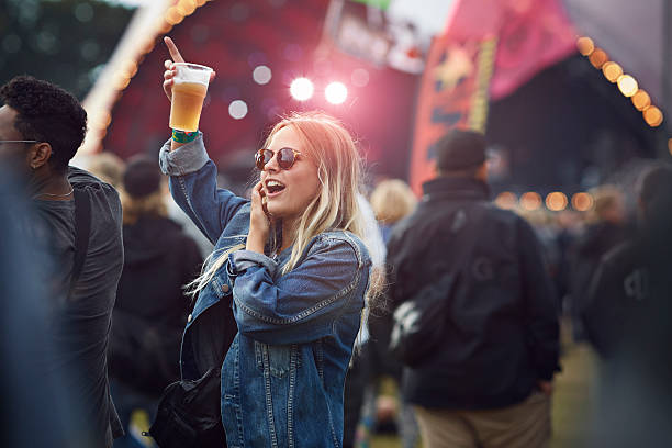 woman cheering with beer at concert - concert stock pictures, royalty-free photos & images