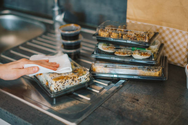 woman disinfecting takeaway sushi boxes - junk food stock pictures, royalty-free photos & images