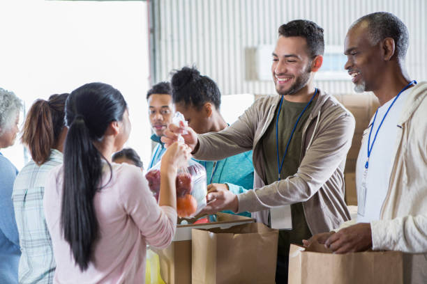 woman donates bag of fruit to food bank - food stock pictures, royalty-free photos & images