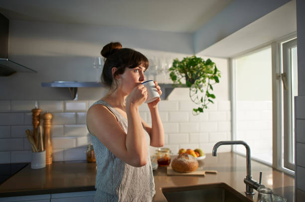 woman drinking from mug in zero waste kitchen. - coffee stock pictures, royalty-free photos & images