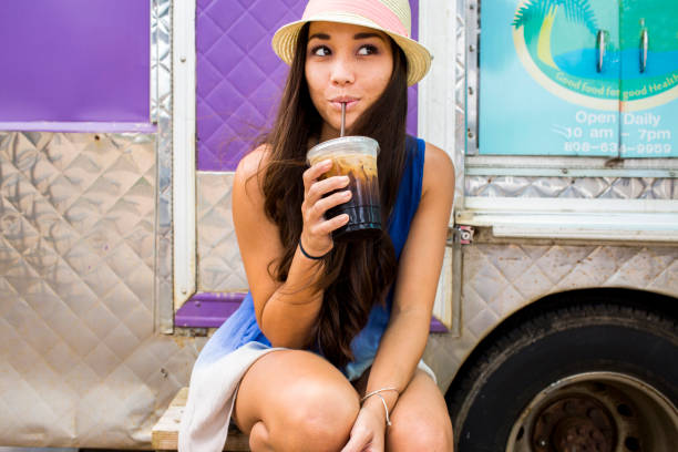 woman drinking ice coffee near food cart - junk food stock pictures, royalty-free photos & images