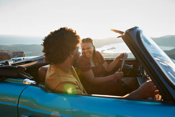 woman driving by boyfriend sitting in car - travel stock pictures, royalty-free photos & images