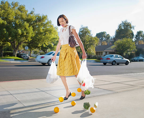 woman dropping groceries on sidewalk - food stock pictures, royalty-free photos & images