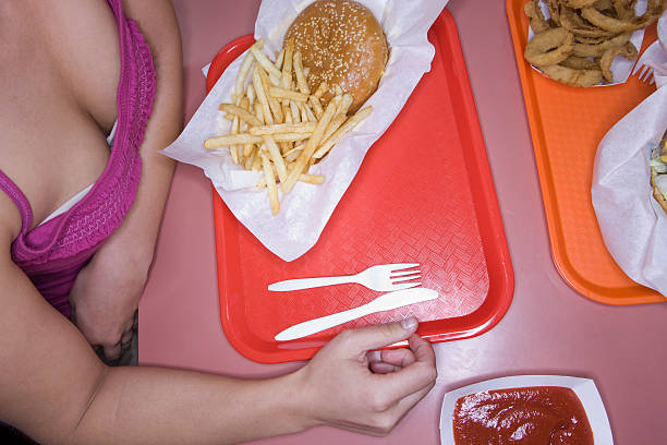 woman eating fast food - junk food stock pictures, royalty-free photos & images