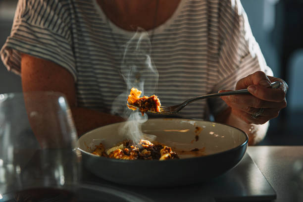 woman eating fusilli pasta with bolognese sauce - food fotografías e imágenes de stock
