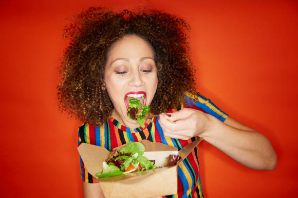 woman eating salad - junk food stock pictures, royalty-free photos & images