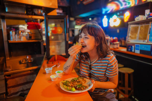 woman eating taco in a bar - food stock pictures, royalty-free photos & images