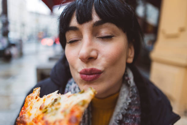 woman enjoying pizza with eyes closed - food stock pictures, royalty-free photos & images