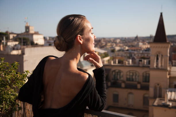 woman enjoying the view from roman rooftop terrace - hairstyle stock pictures, royalty-free photos & images