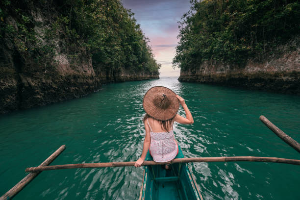 woman exploring a river on small boat at sunset, philippines - travel stock pictures, royalty-free photos & images