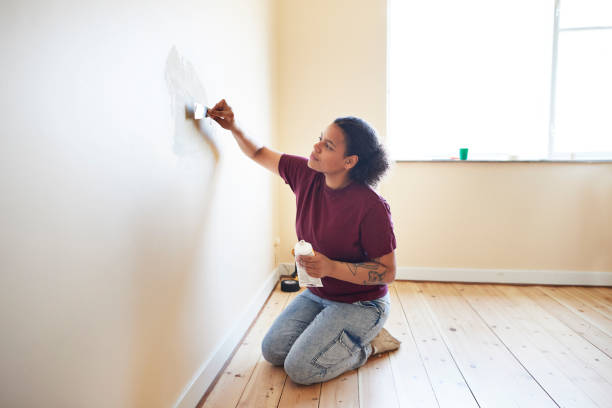 woman finishing wall while renovating home - home decoration stock pictures, royalty-free photos & images
