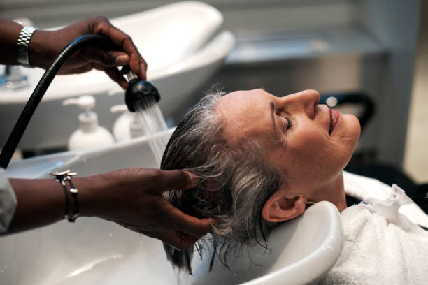 woman getting hair washed at salon - hairstyle fotografías e imágenes de stock