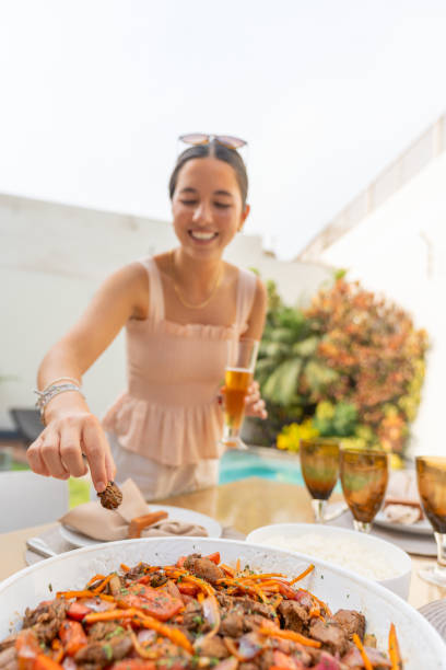 woman grabbing food from a garden table - garden decoration stockfoto's en -beelden
