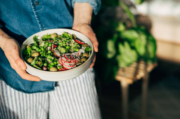 woman hands eating vegan salad of baked vegetables, avocado, tofu and buckwheat buddha bowl, top view. plant based food concept. - food stock pictures, royalty-free photos & images