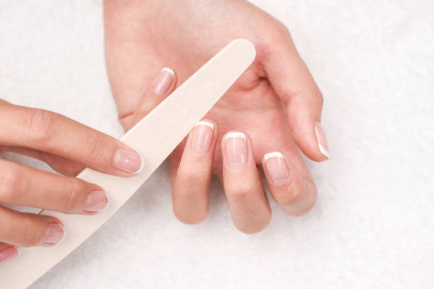 woman hands in a nail salon receiving a manicure. - nails art stock pictures, royalty-free photos & images
