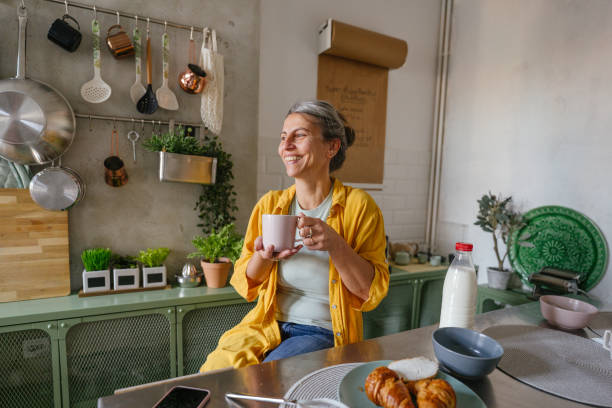 woman having a first morning coffee in the kitchen - coffee stock pictures, royalty-free photos & images