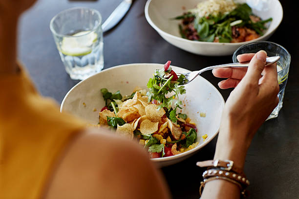 woman having food at restaurant table - food stock pictures, royalty-free photos & images