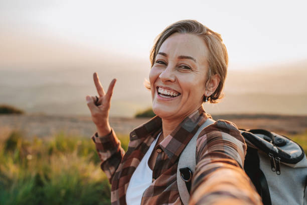 woman hiking in the mountain selfie with smartphone - travel stock pictures, royalty-free photos & images