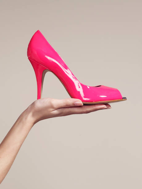 woman holding a high heel shoe - fashion stock pictures, royalty-free photos & images