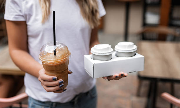 woman holding plastic glass of iced coffee - junk food stock pictures, royalty-free photos & images