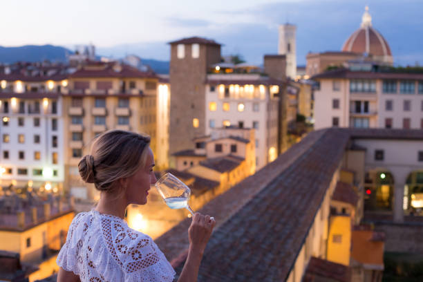 woman in beautiful white dress enjoying a glass of wine with the view of florence - travel stock pictures, royalty-free photos & images