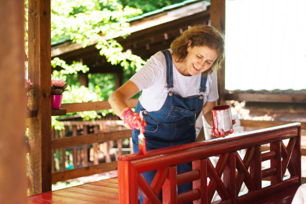 woman is coloring the fence at home - garden decoration stock pictures, royalty-free photos & images