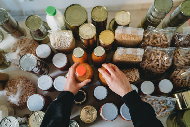 woman is rearranging the kitchen pantry - food stock pictures, royalty-free photos & images